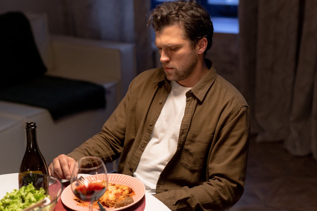 un homme de type européen qui mange épicé et boit de l'alcool