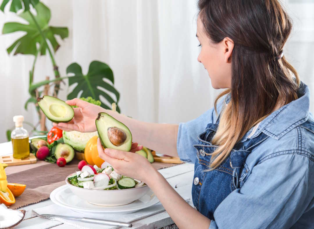 Une femme qui mange de l'avocat pour un bon équilibre oméga 3