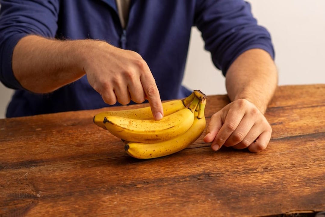 Un homme qui montre du doigt des bananes