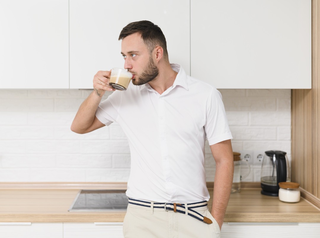 Un homme avec un bien-être digestif qui boit son café du matin