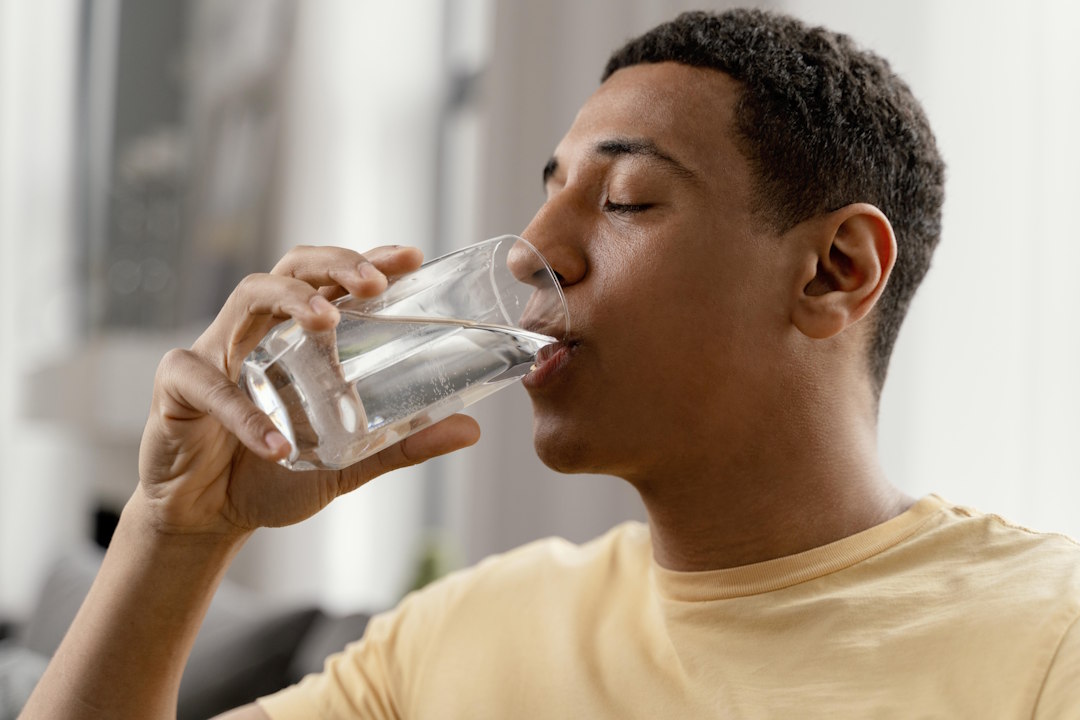 Un jeune homme qui boit trop d'eau