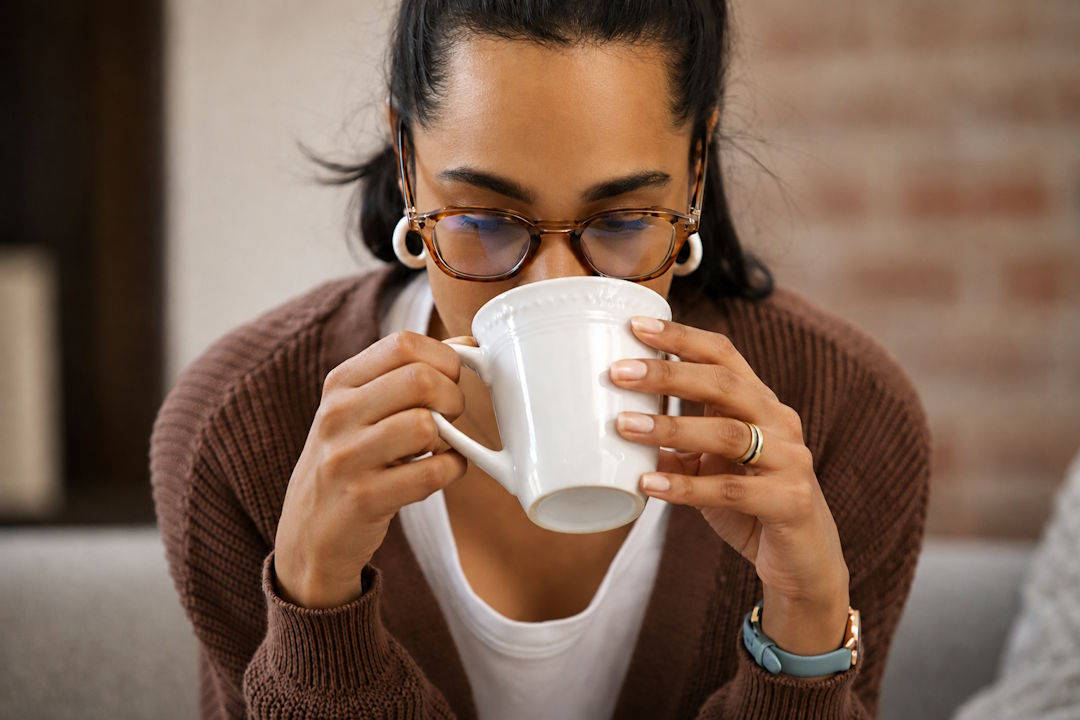 Une femme qui boit une boisson tiède