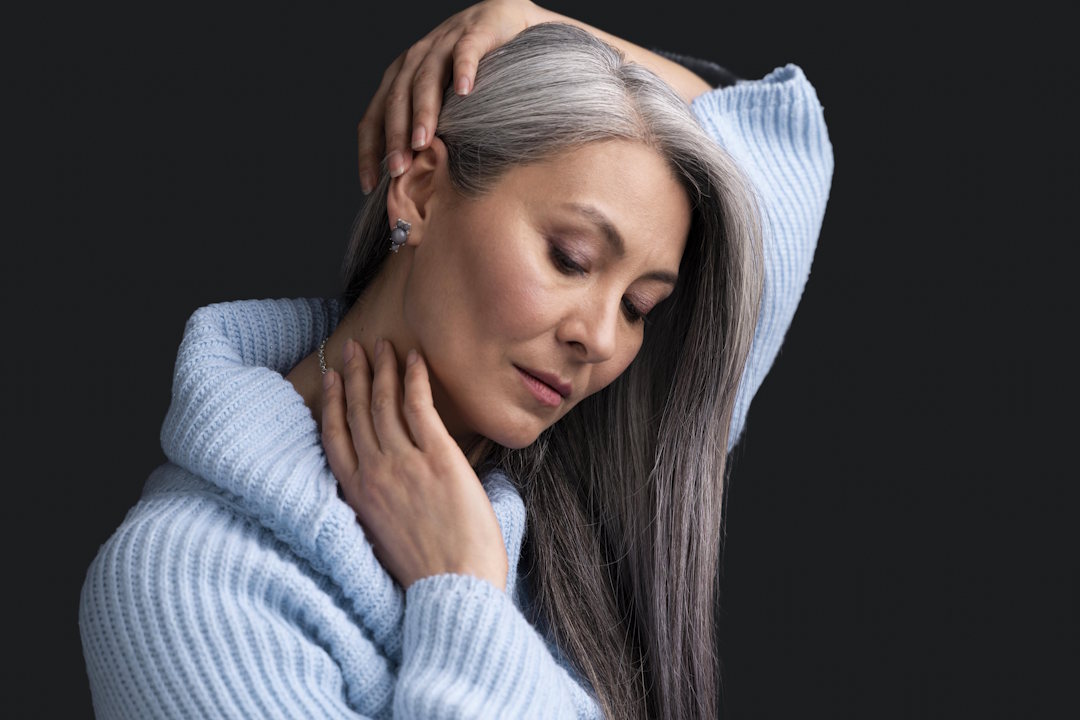 Une femme âgée qui se touche les cheveux