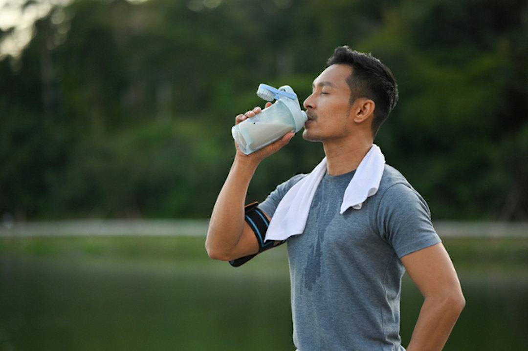 Un homme qui bit de la whey