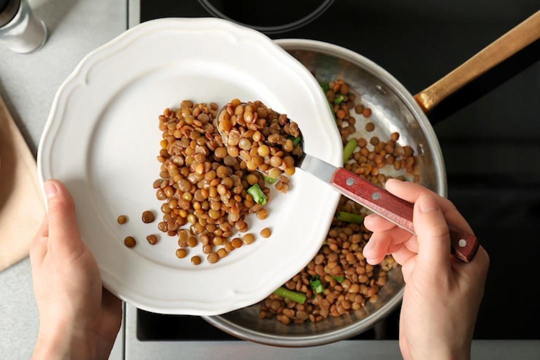 Une personne qui cuisine des légumineuses