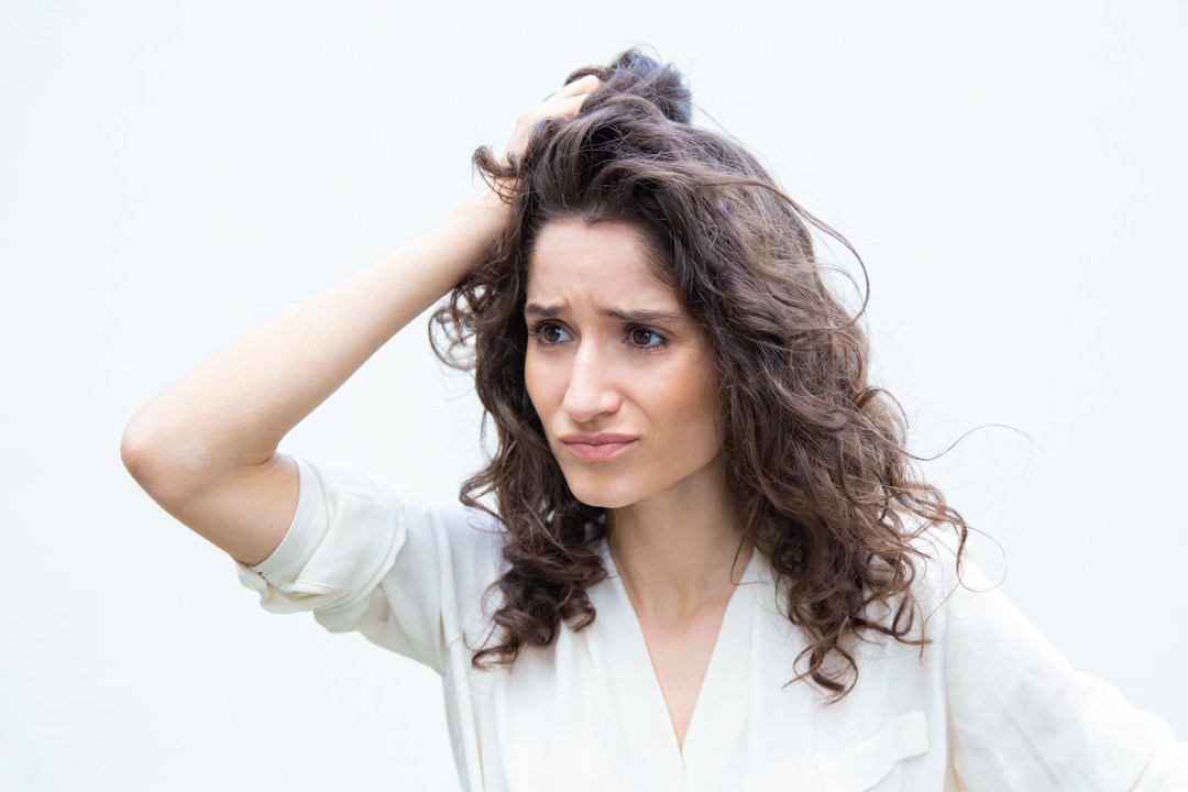 Une femme qui se gratte les cheveux