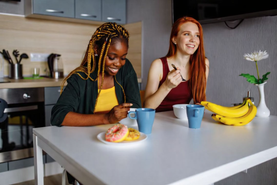 Deux jeunes femmes qui prennent un petit déjeuner avec des bananes