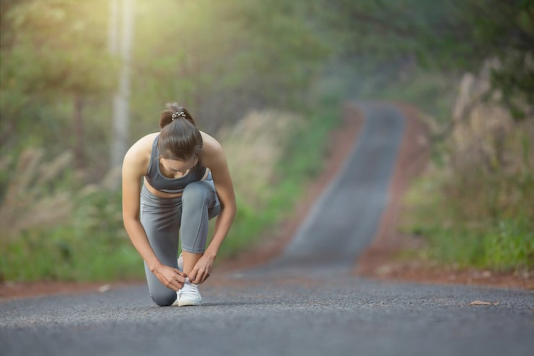 Une femme qui souffre de douleur pieds pendant une course à pieds