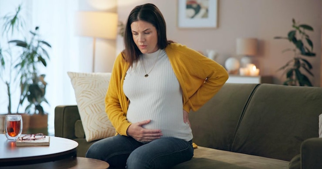 Une femme enceinte avec des douleurs dans le ventre