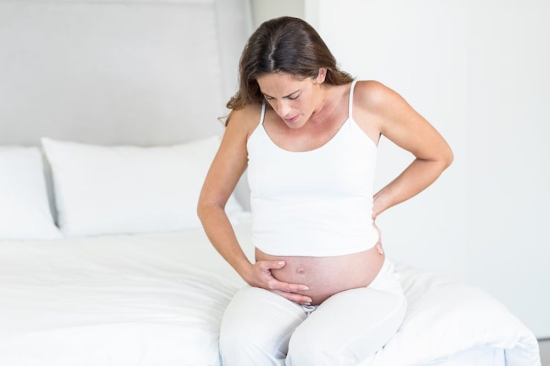 Une femme enceinte qui ressent une douleur 