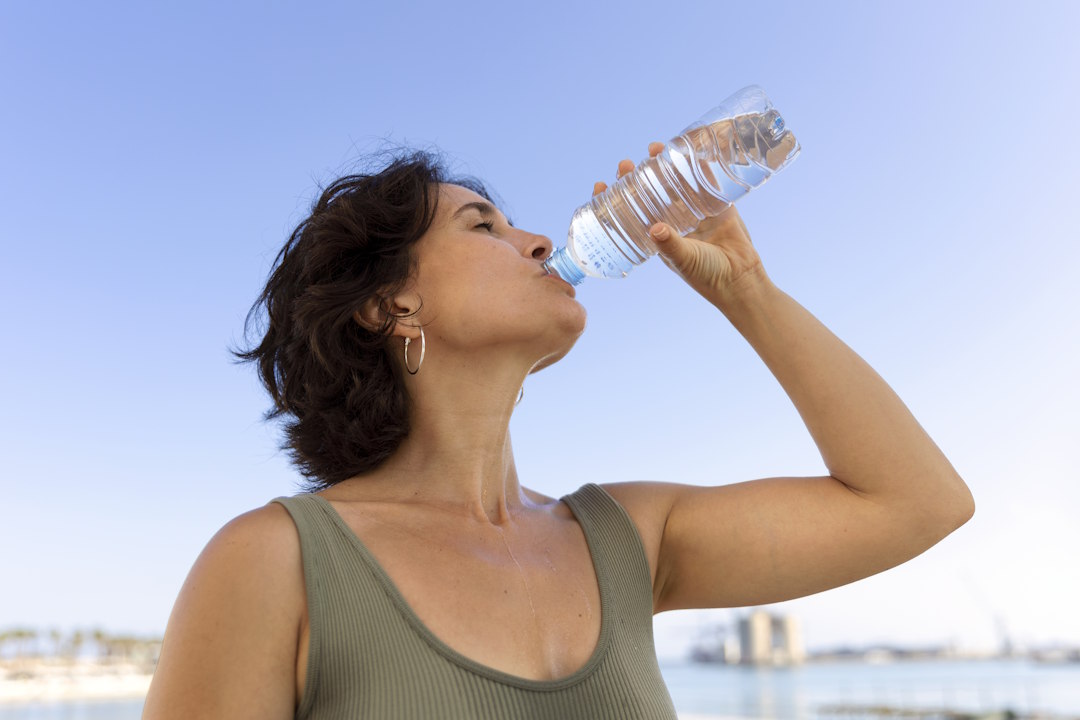 Une femme qui boit de l'eau pour la bonne hydratation