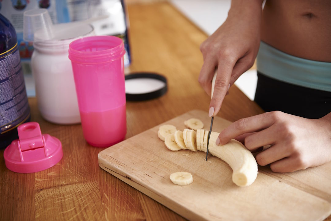 Une femme qui mange une banane après la musculation