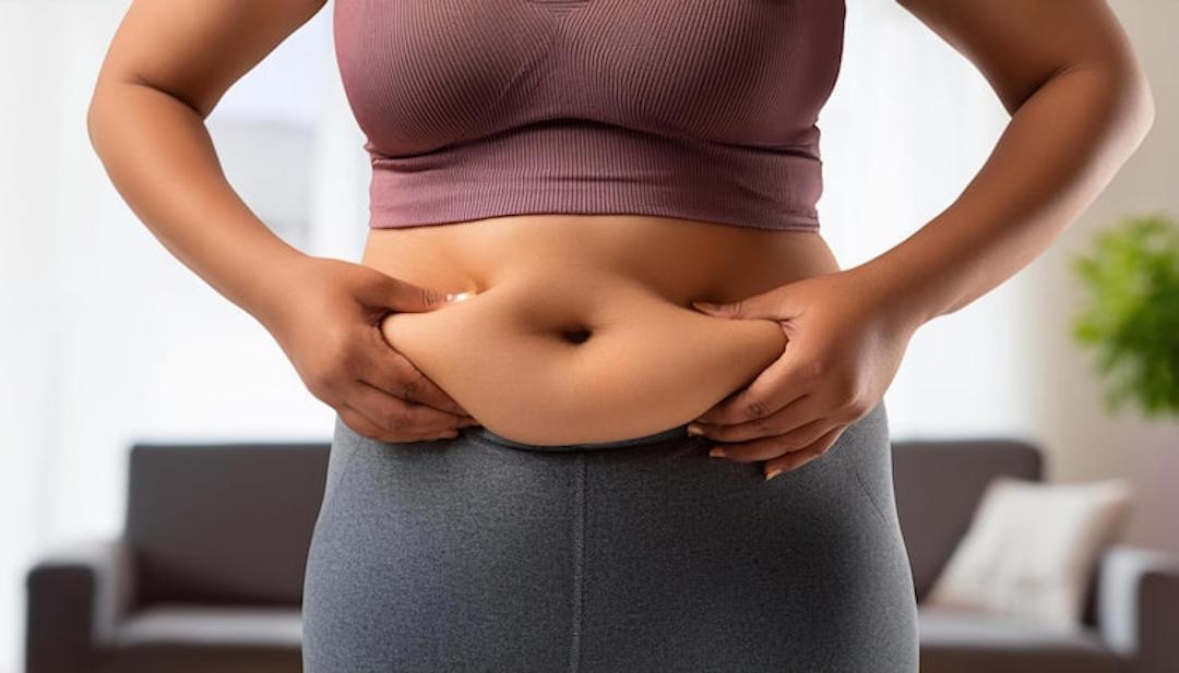 Une femme qui mesure sa graisse abdominale dans le salon