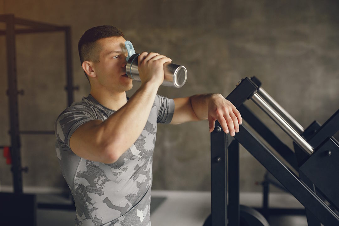 Un homme à la salle de musculation en prenant de la BCAA