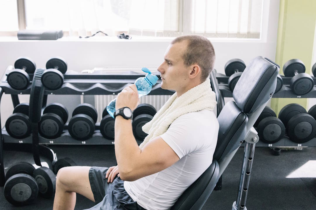 Un homme qui s'hydrate après un exo de musculation