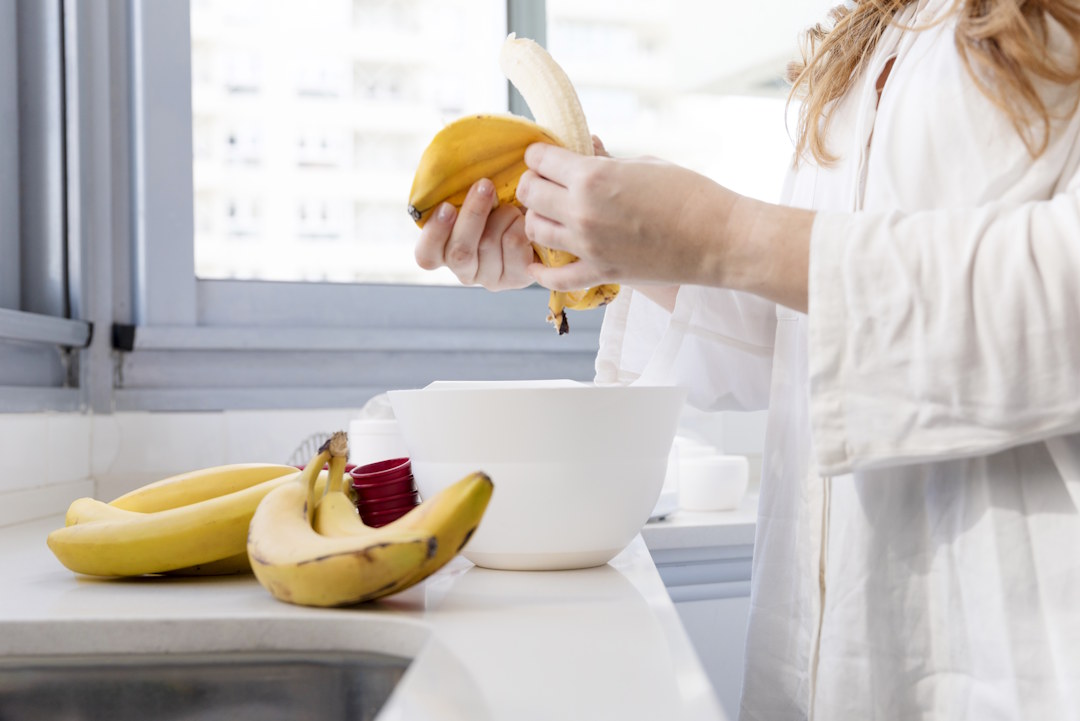 Une femme qui mange de la banane pour les protéines