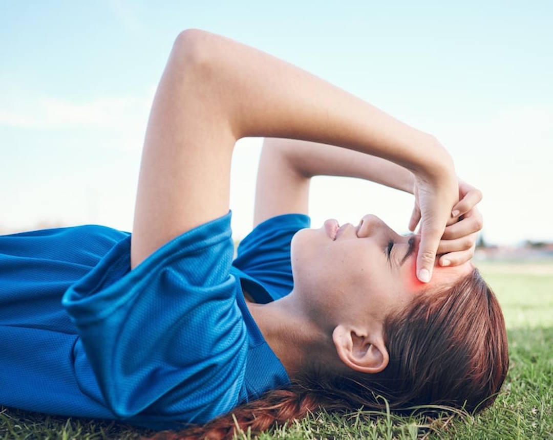 Une femme qui souffre de maux de tête et d'insolation
