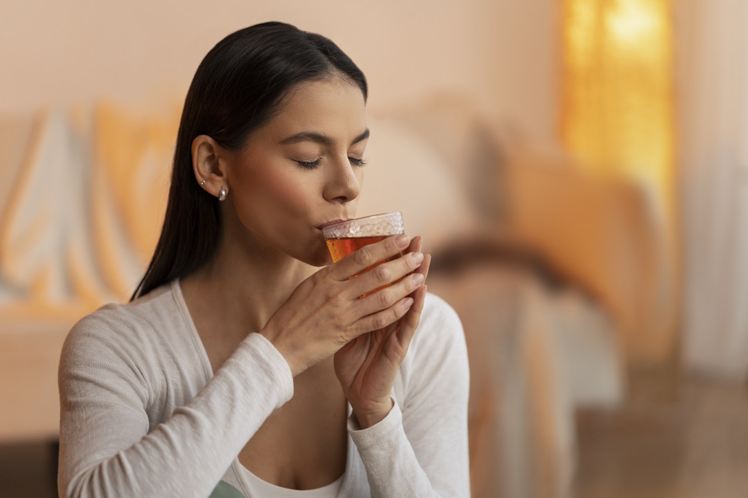 Une femme qui boit une infusion d’achillée millefeuille 