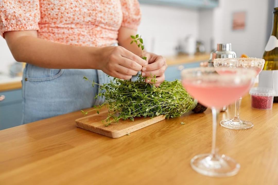 Une femme qui prépare de l'origan dans la cuisine