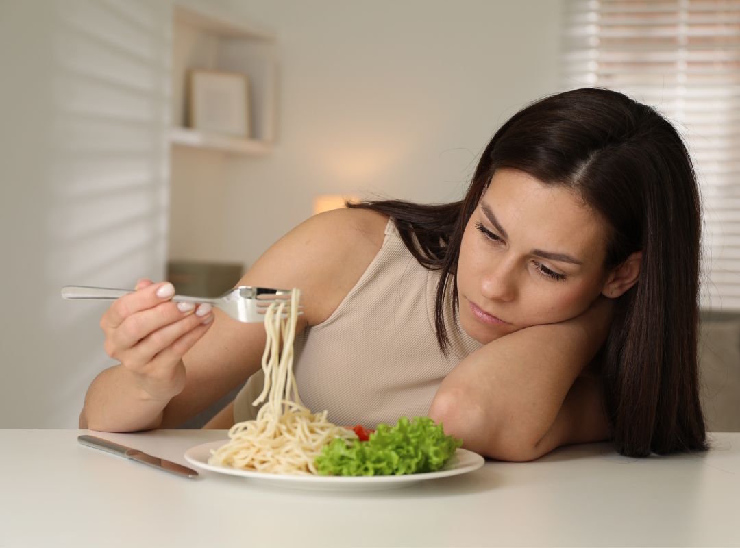 Une femme qui n'as pas d'appétit, un des symptômes d'un manque de vitamine B12 