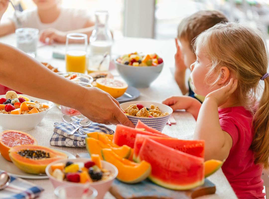 Les enfants qui prennent le petit déjeuner avec de la papaye