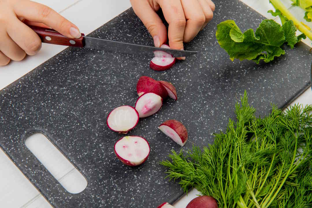Une femme qui pr&eacute;pare des radis en cuisine