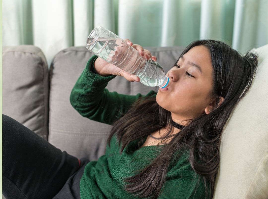 Une femme qui s'allonge et s'hydrate 