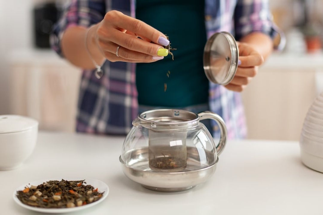 Une personne qui prépare une tisane à base de feuilles d'orties