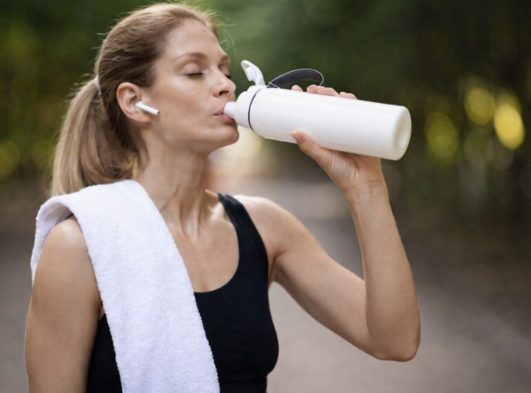 Une femme qui prends son whey après une séance