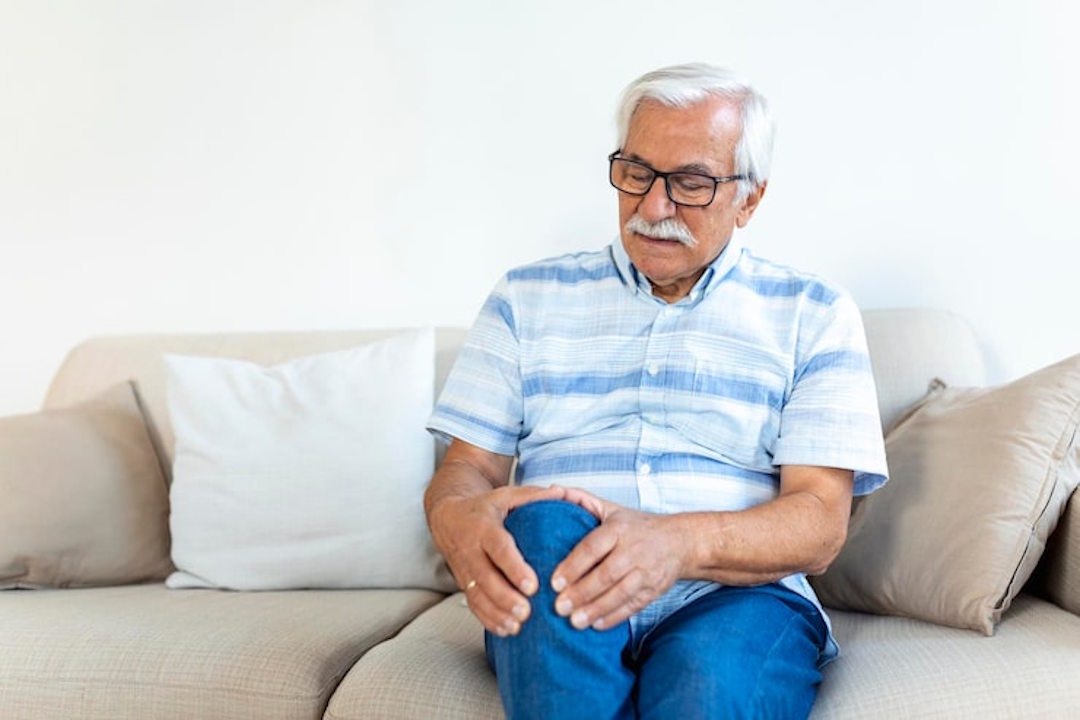 Un homme âgé qui a mal au genou