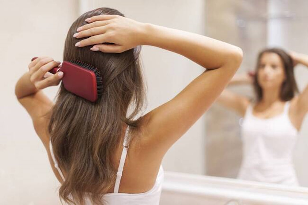 Une femme qui se peigne les cheveux