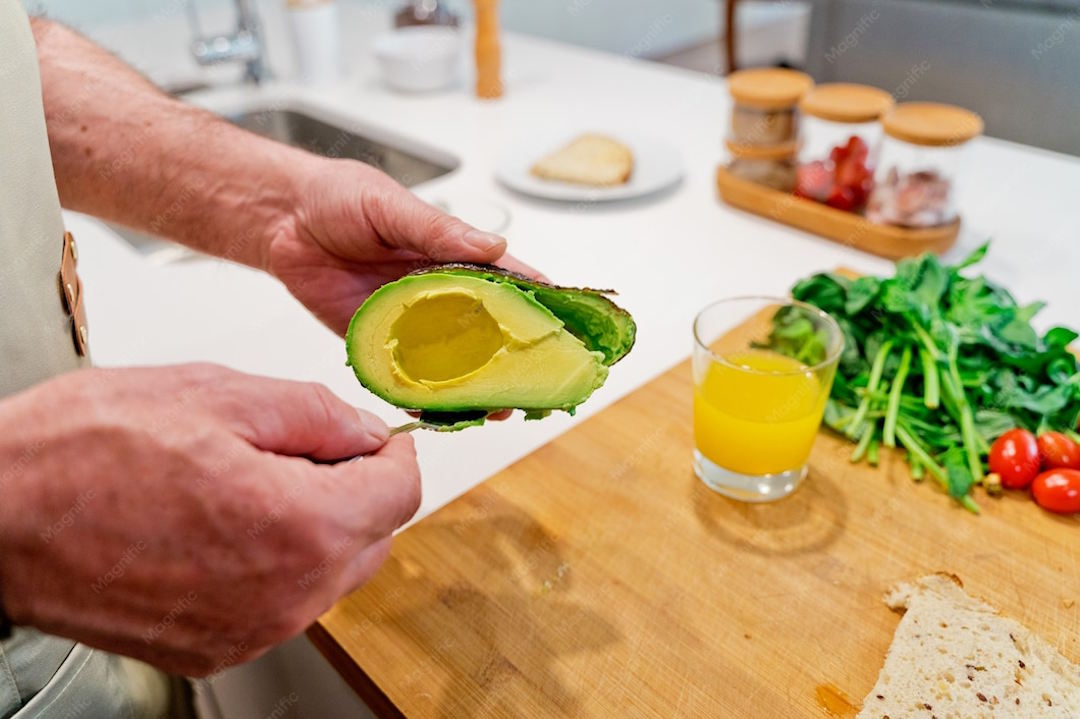 Un homme qui prépare un avocat dans sa cuisine
