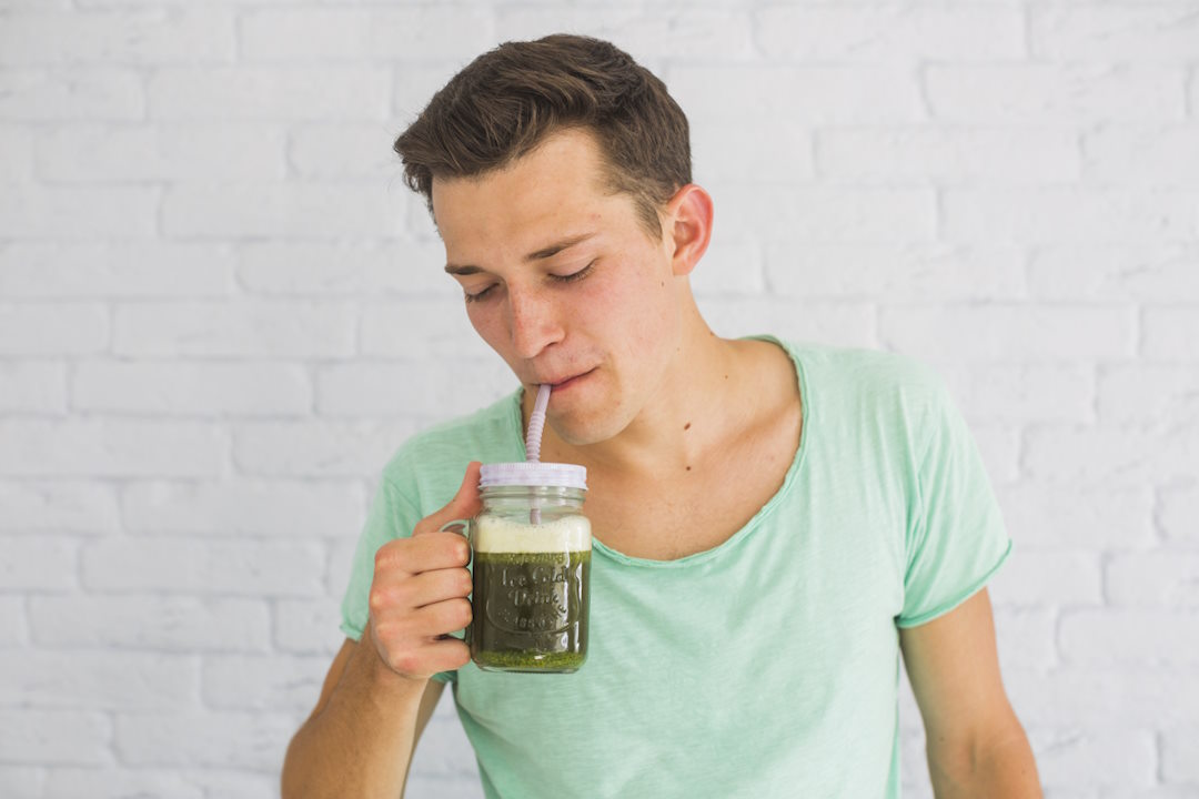Un homme qui boit de l'argile verte