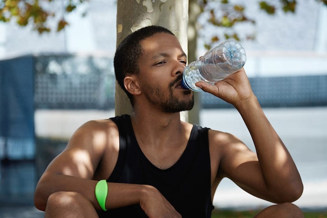 Un homme qui boit de l'eau riche en électrolytes