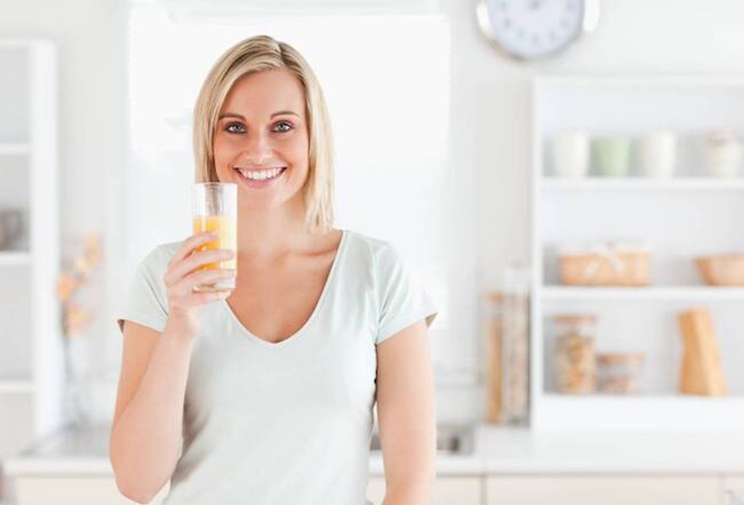 Une femme qui boit de la vitamine C
