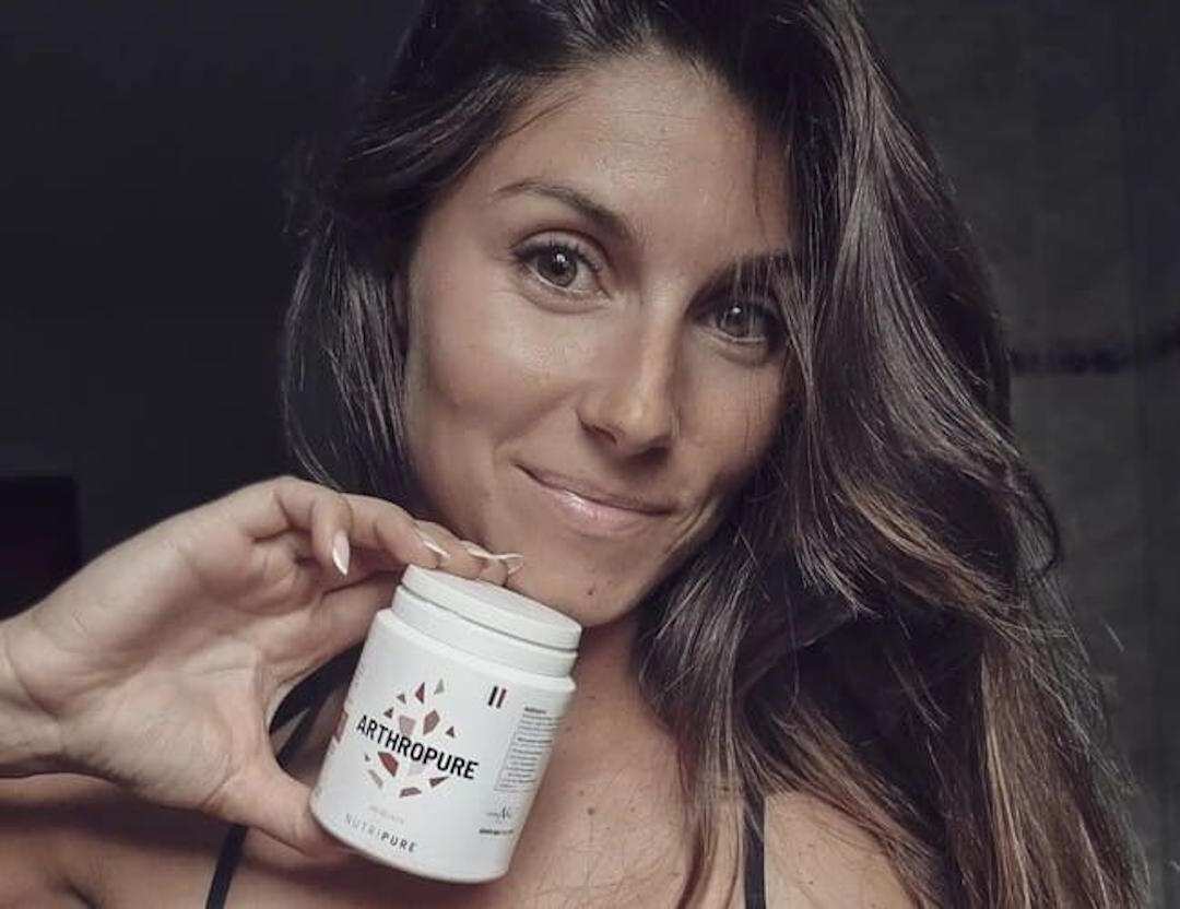Une femme qui tient un flacon d'Arthropure de Nutripure