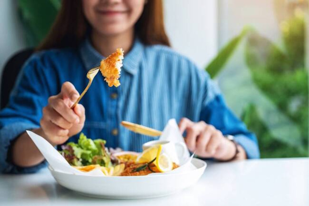 Une femme qui mange un plat riche en citrate de magnésium