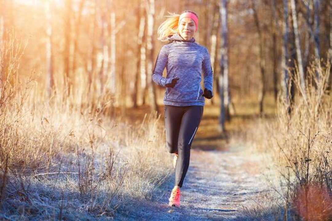Une femme qui fait sa course à pied dans la forêt