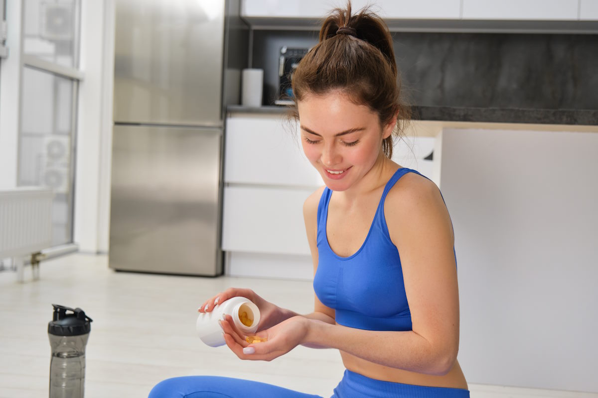 Une femme qui prend des compléments alimentaires riches en vitamine B12