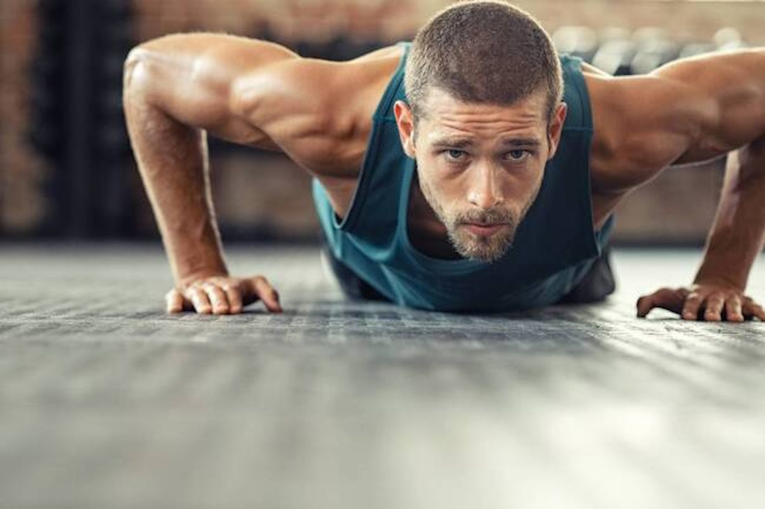 Un homme qui fait des pompes dans une salle de sport