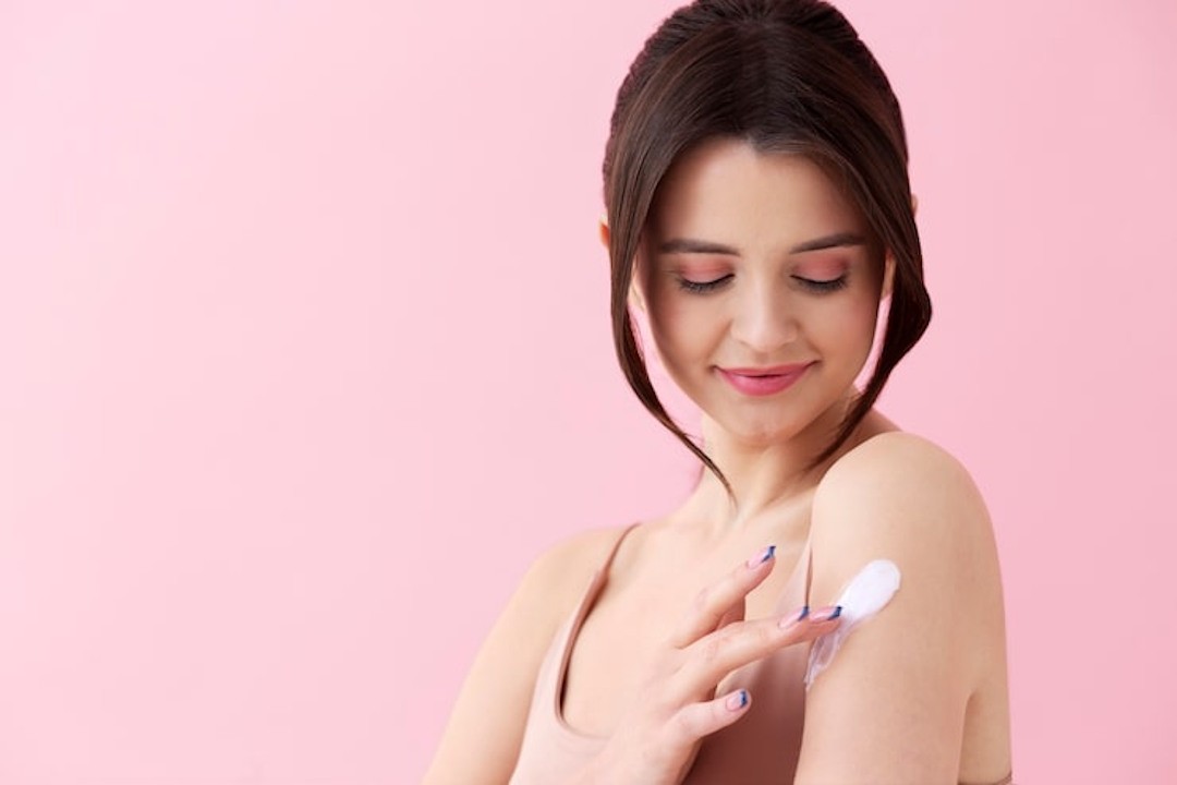 Une femme qui applique de l'Oxyde de zinc sur la peau
