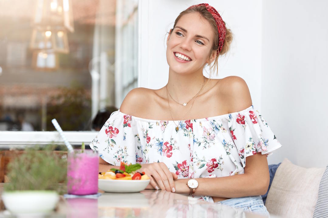 Une femme qui mange avec le sourire grâce aux bienfaits du fenugrec