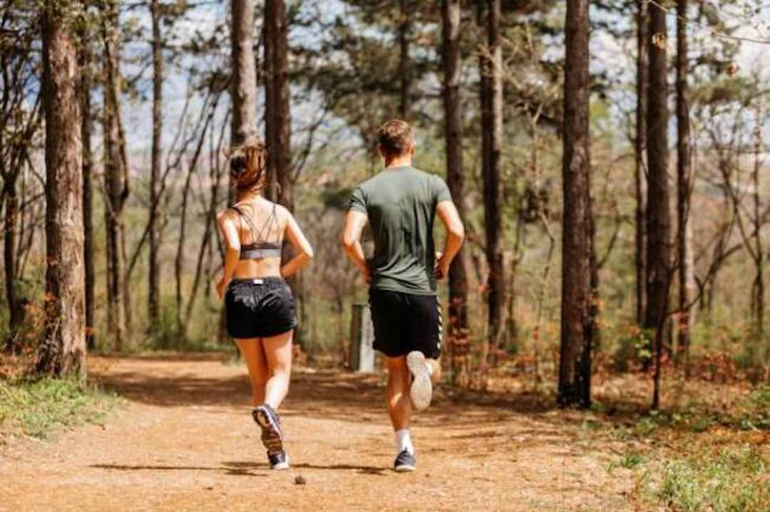 Un homme et une femme qui font de la course à pied dans la forêt 