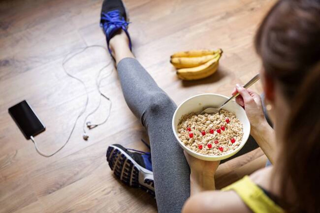 Une femme qui mange des fruits et des graines pour un meilleur apport en Créatine