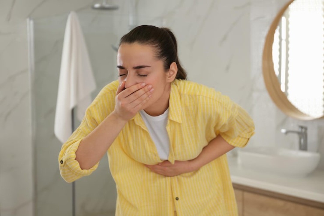 Une femme qui a envie de vomir à cause des effets secondaires de la mélatonine