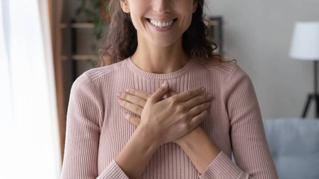 Une femme qui sourit avec de belles dents grâce à un bon apport en magnésium