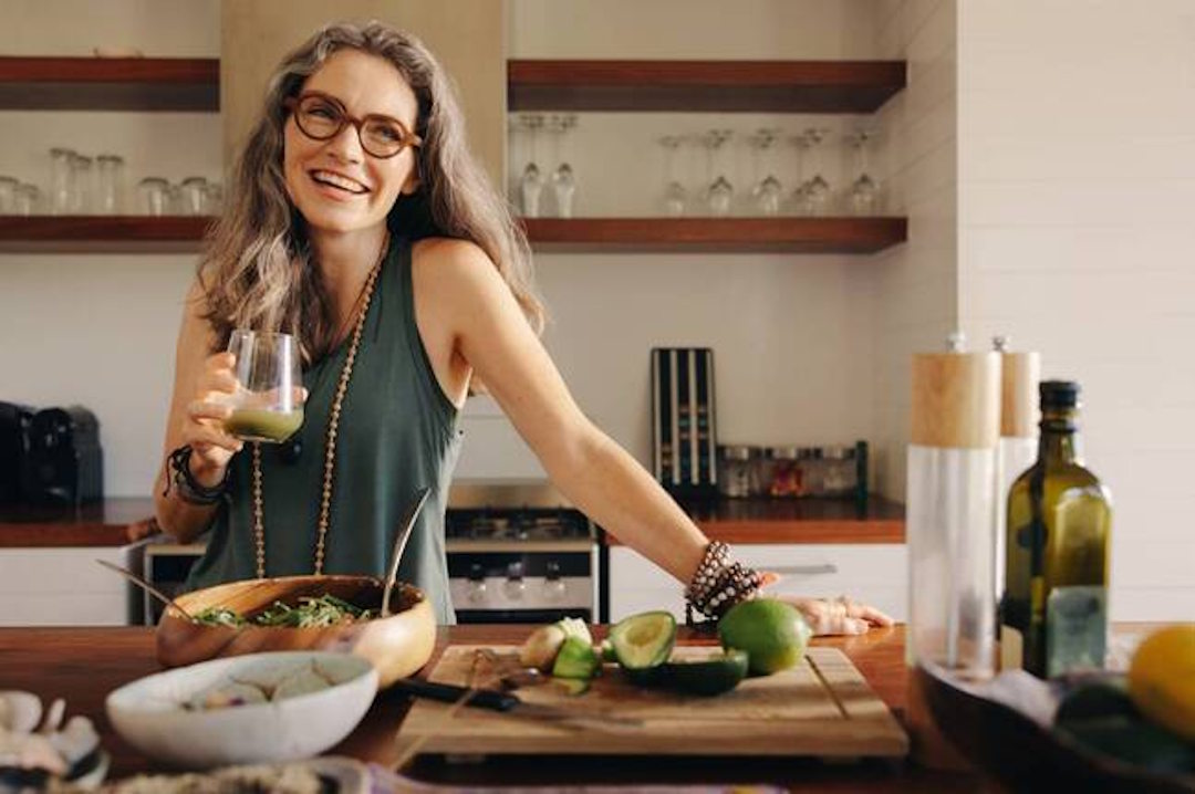 Une femme dans une cuisine qui prépare à manger avec un peu d'Ashwagandha