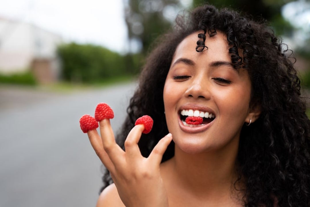 Une femme qui mange des framboises