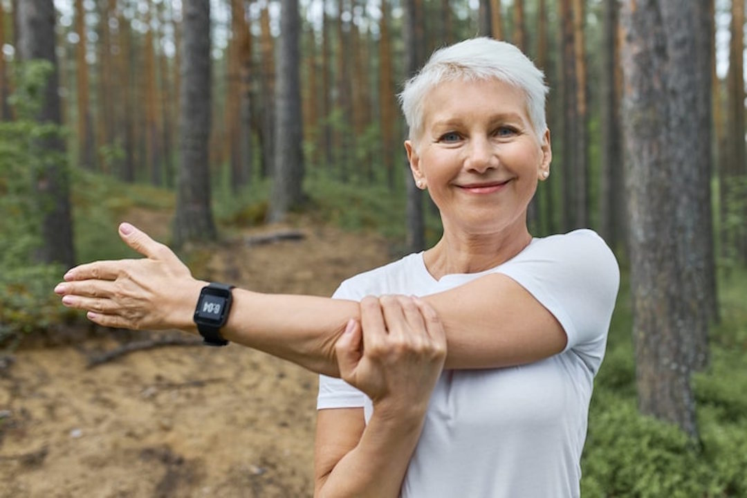 Une femme âgée qui fait des étirements avant le sport