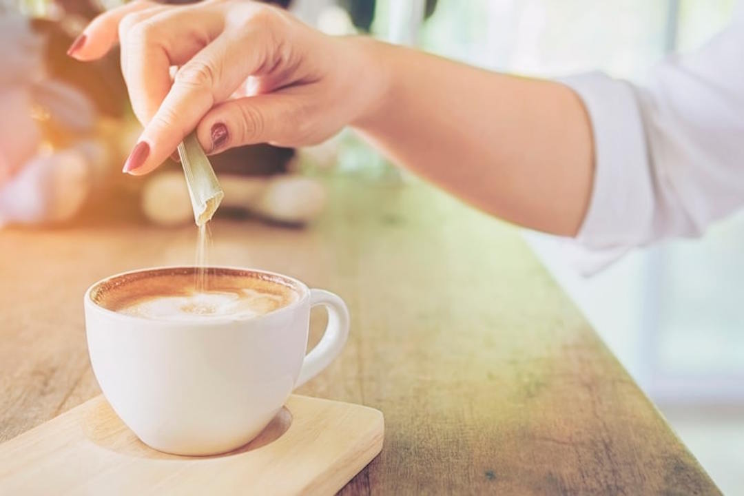 Une femme qui verse de la glycine dans une tisane